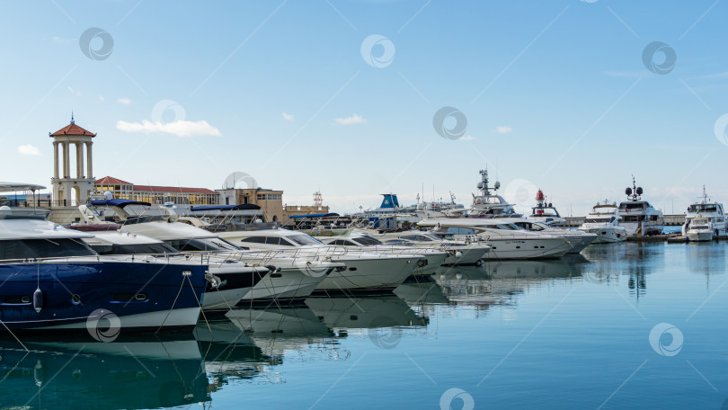 Скачать Корабли, яхты и катера на голубой глади Черного моря у причала Морского торгового порта Сочи. Центр города-курорта. Сочи, Россия - 23 ноября 2020 г. фотосток Ozero