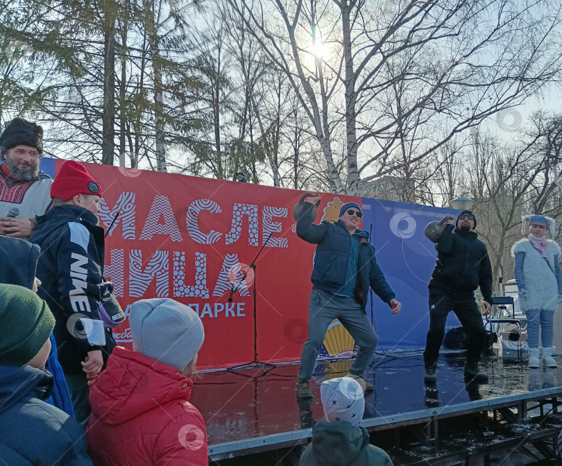 Скачать На празднике  "Масленица "  мужчины поднимают вверх гири фотосток Ozero