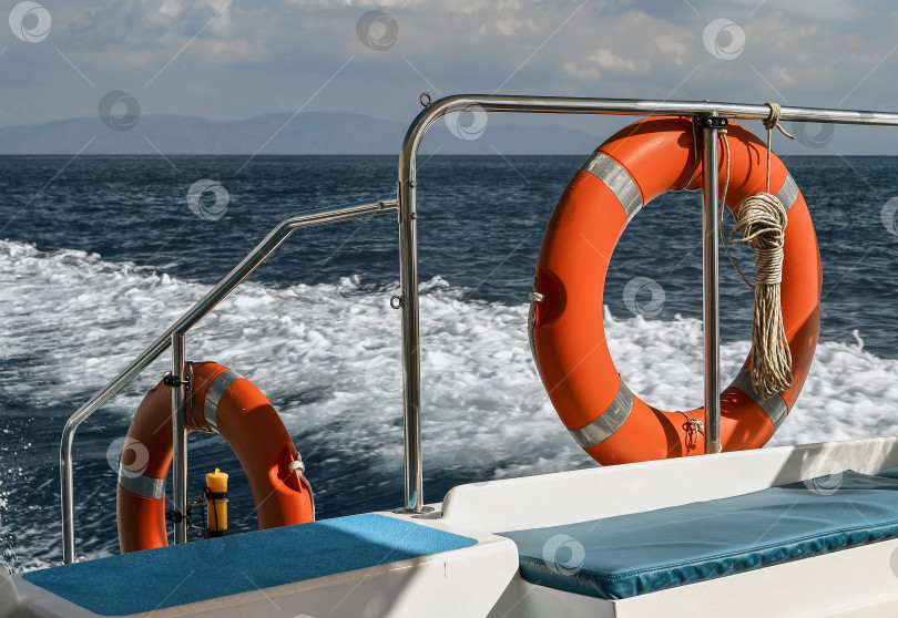 Скачать Задняя часть прогулочного катера с пенным следом на воде. фотосток Ozero