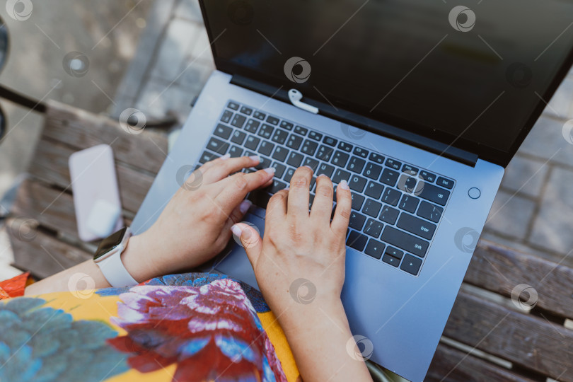 Скачать Женские руки работают на ее ноутбуке, сидя в парке фотосток Ozero
