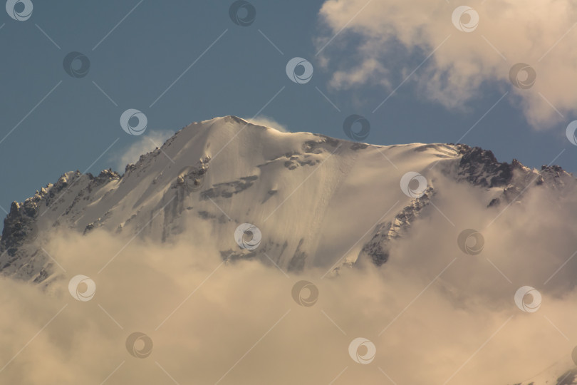 Скачать Заснеженные горные вершины среди облаков, Киргизский хребет, урочище Чонкурчак, страна Кыргызстан. фотосток Ozero