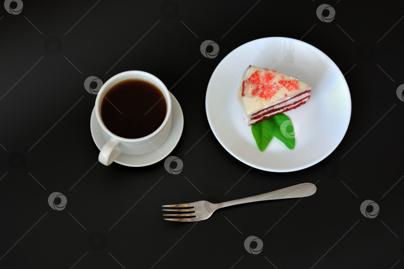 Скачать Тарелка с куском торта "Красный бархат", вилкой и чашкой горячего черного кофе на черном фоне. фотосток Ozero