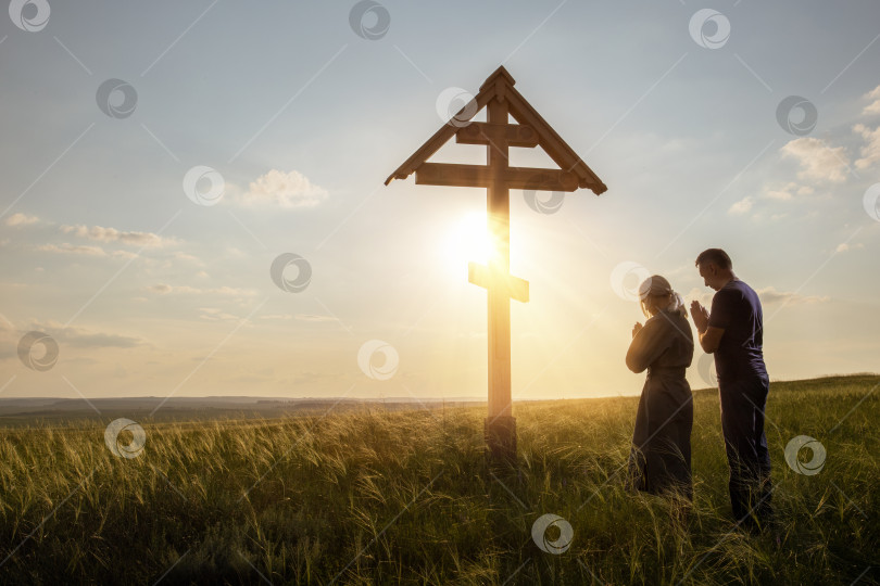Скачать пара, молящаяся Богу на открытом воздухе на закате. фотосток Ozero