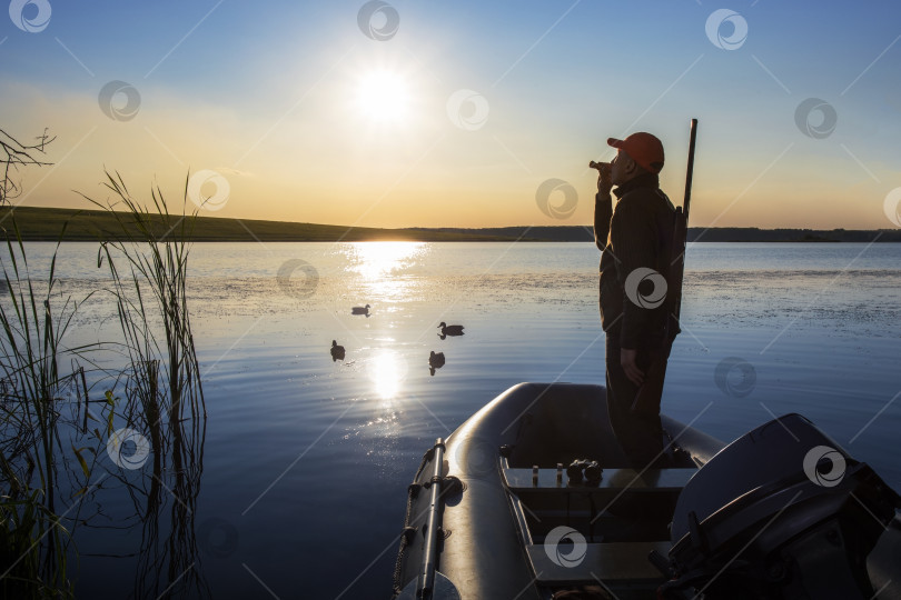 Скачать Охотник, зовущий уток на озере. фотосток Ozero