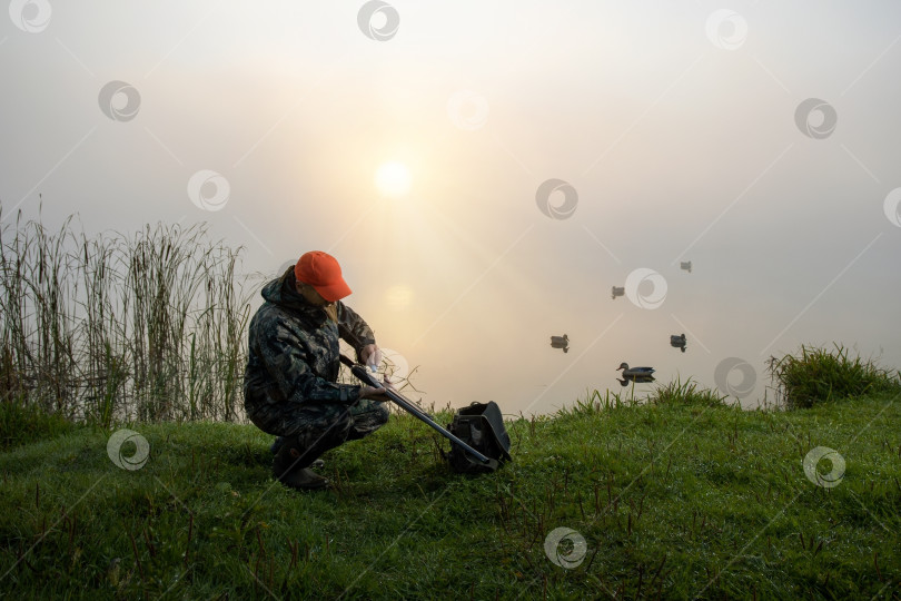Скачать Мужчина-охотник в камуфляжной одежде охотится на природе. фотосток Ozero