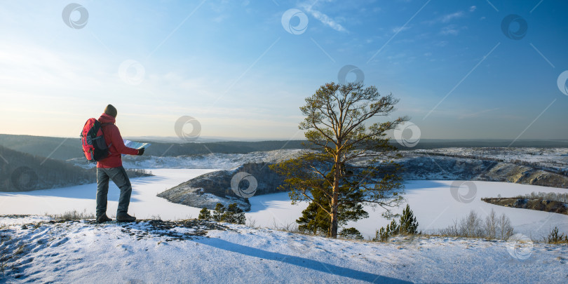 Скачать мужчина, совершающий пеший поход с картой в горах в зимний сезон. панорамный баннер фотосток Ozero