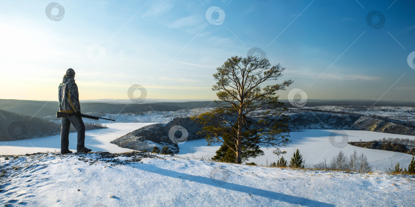 Скачать Охотник в камуфляже с дробовиком на зимней охоте. фотосток Ozero