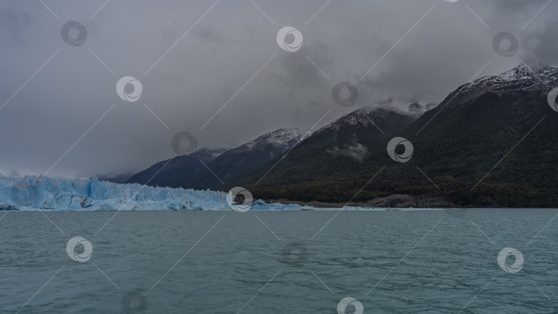 Скачать Стена голубого льда возвышается над бирюзовым ледниковым озером. фотосток Ozero