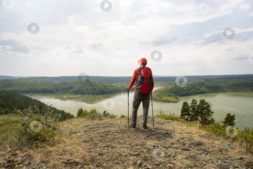 Скачать Активный мужчина, совершающий кавказские походы в горы с рюкзаками и походными палками, наслаждаясь фотосток Ozero