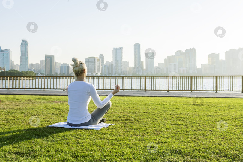 Скачать Зрелая женщина занимается йогической медитацией в парке на рассвете. фотосток Ozero