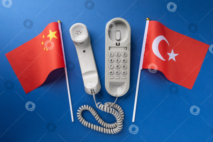 Скачать Флаг Китая, Турции и старый проводной телефон на синем фоне, концепция на тему телефонных разговоров между странами фотосток Ozero