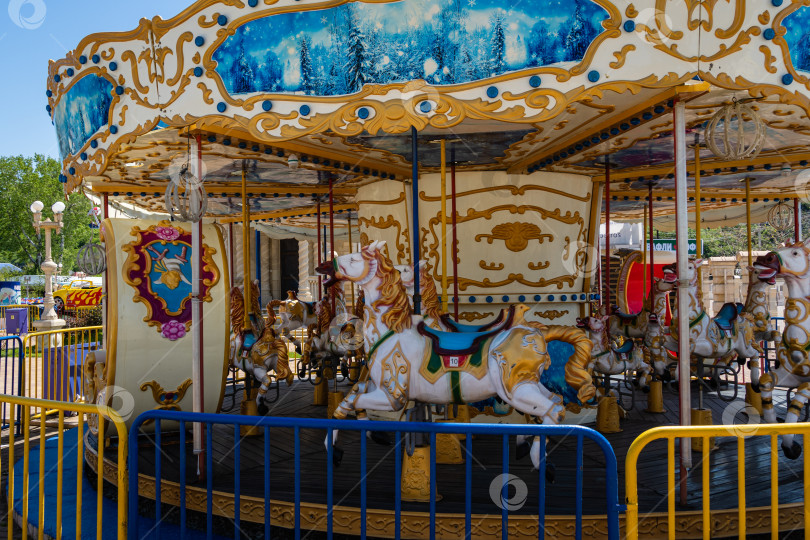 Скачать Парк развлечений на Черноморской набережной в Архипо-Осиповке. Детская карусель с разноцветными лошадками в стиле ретро. Крупный план. фотосток Ozero