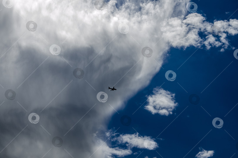 Скачать Самолет в голубом небе с белыми облаками. Облачный пейзаж. фотосток Ozero