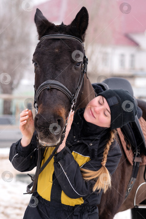 Скачать Человек, проявляющий привязанность к лошади зимой. фотосток Ozero