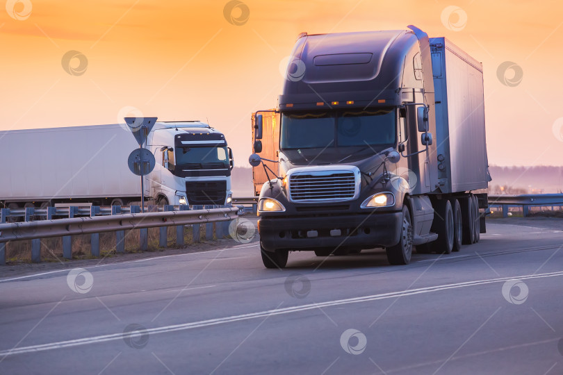 Скачать грузовики едут по шоссе на закате фотосток Ozero