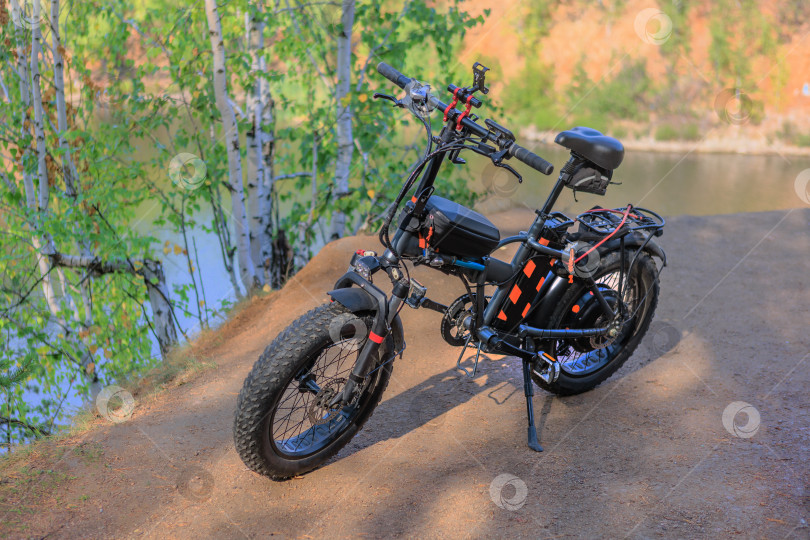 Скачать Электрический велосипед на берегу реки фотосток Ozero