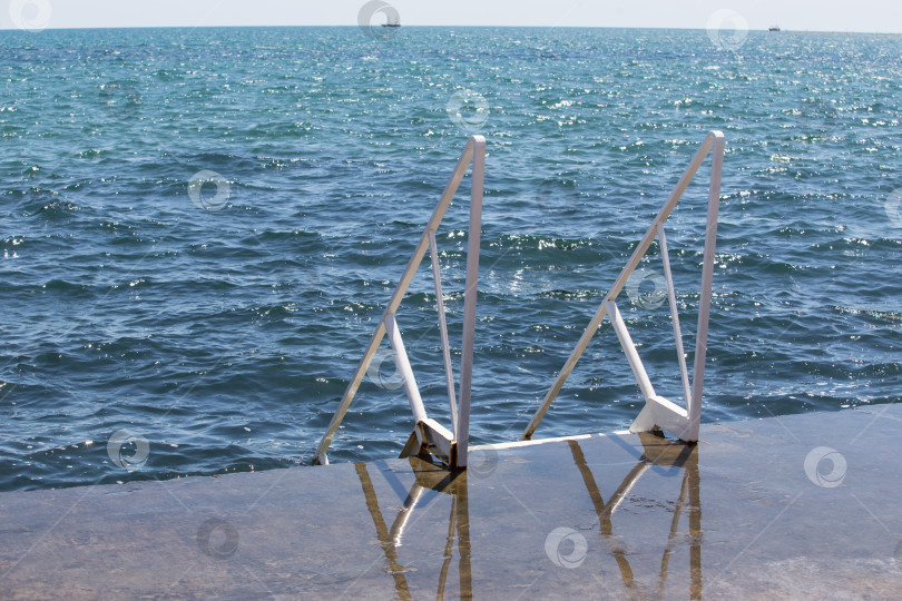 Скачать Лестница с поручнями к воде на берегу моря фотосток Ozero