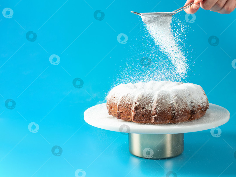 Скачать Женская рука посыпает торт сахарной пудрой фотосток Ozero