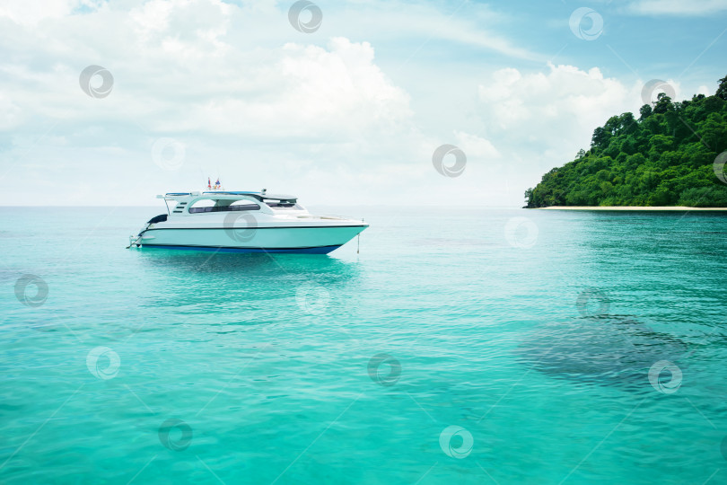 Скачать Прекрасный вид на тропический экзотический остров с кристально чистым бирюзовым морем и белой яхтой. фотосток Ozero