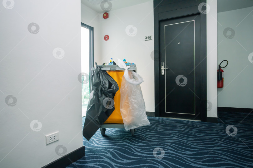 Скачать Тележка уборщицы с уборочным оборудованием в коридоре отеля. фотосток Ozero