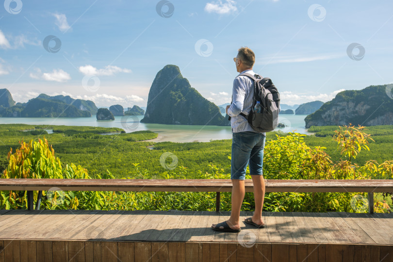 Скачать Зрелый мужчина-путешественник наслаждается видом на залив Пханг Нга, Таиланд. Юго-Восточная Азия фотосток Ozero
