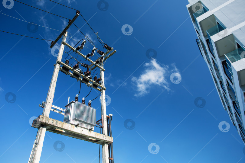 Скачать Электрический трансформатор в городе на фоне голубого неба. фотосток Ozero