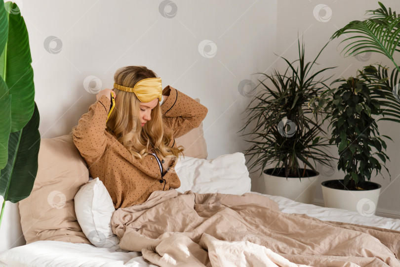 Скачать Женщина поправляет повязку на голову в спальне. фотосток Ozero