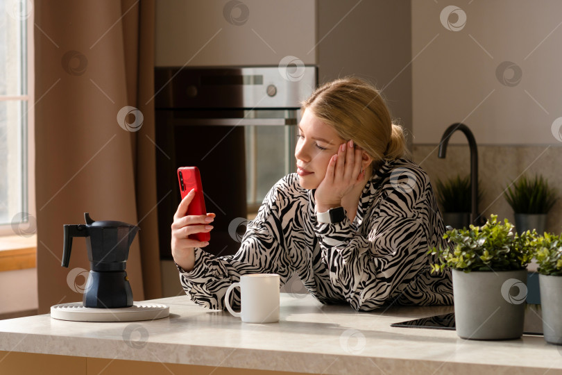 Скачать Женщина, работающая в режиме многозадачности с телефоном и кофе. фотосток Ozero