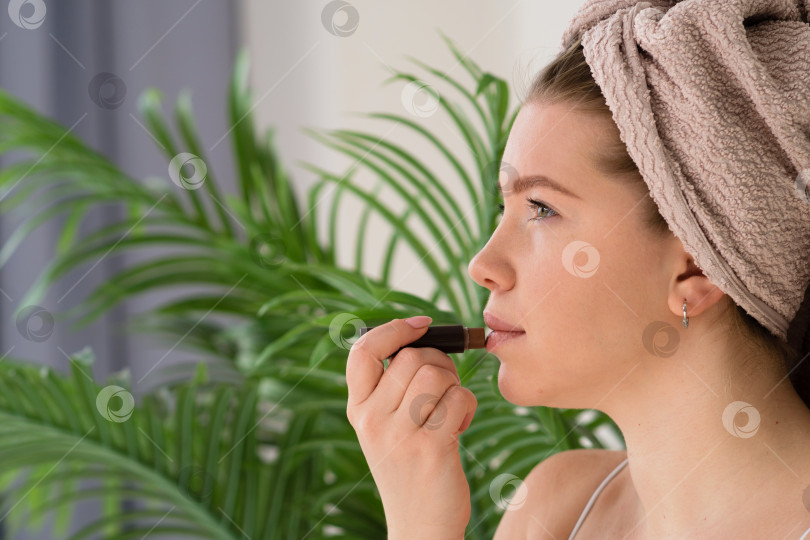 Скачать Женщина наносит макияж, обернувшись полотенцем фотосток Ozero