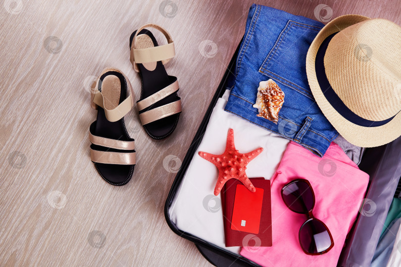 Скачать Открытый чемодан с женской одеждой, шляпкой, паспортом фотосток Ozero