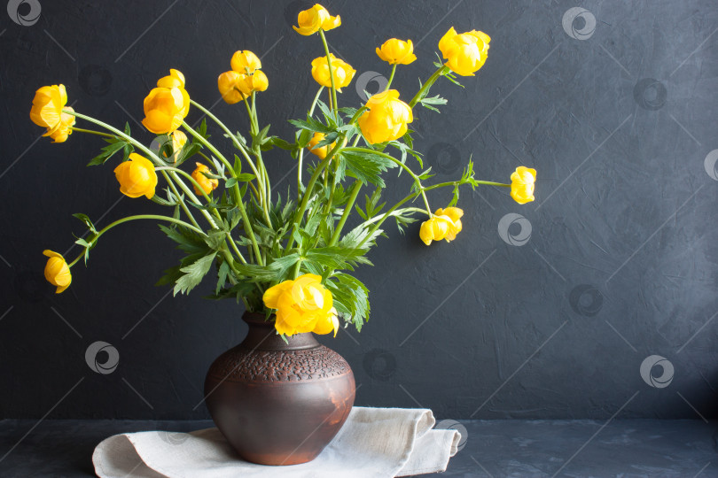 Скачать Весенний фон. Букет желтых весенних цветов в глиняной вазе на сером фоне. фотосток Ozero