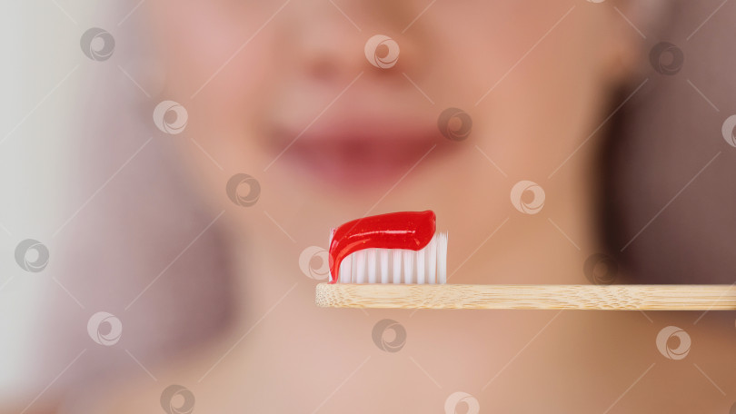 Скачать Крупный план красной зубной пасты на бамбуковой щетке. фотосток Ozero