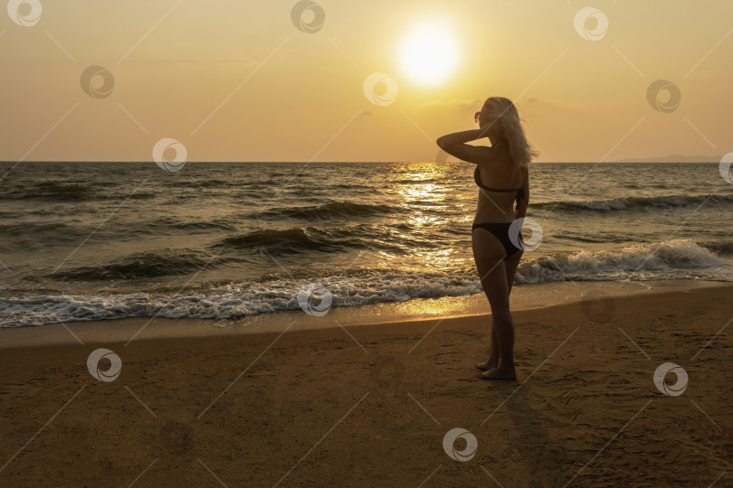 Скачать Женщина на тропическом пляже на закате. фотосток Ozero
