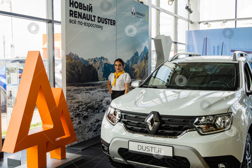 Скачать Девушка представляет новый белый внедорожник Renault Duster в автосалоне Renault Mega Адыгея. Автомобиль крупным планом. Автосалон Renault в Мега Адыгея. фотосток Ozero