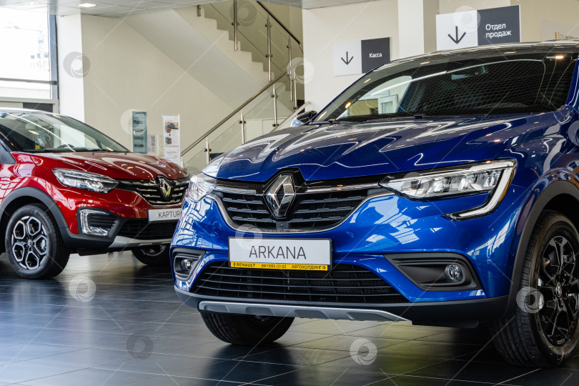 Скачать Синий внедорожник Renault Arkana в автосалоне. Крупный план. На заднем плане красный внедорожник Renault Captur. Автосалон Renault в Мега Адыгея. фотосток Ozero