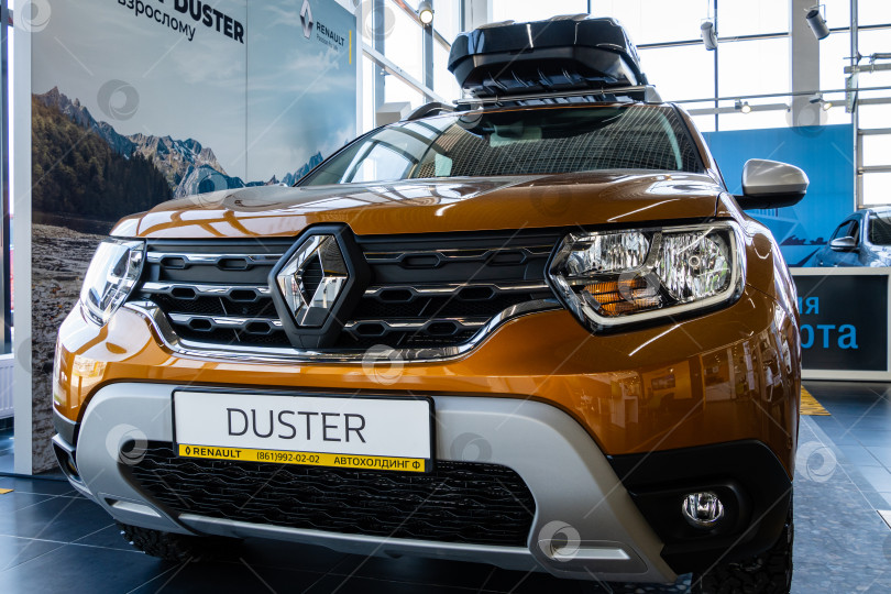 Скачать Внедорожник Renault Duster золотистого цвета с багажником на крыше в автосалоне Renault. Автомобиль крупным планом. Автосалон Renault в Мега Адыгея фотосток Ozero