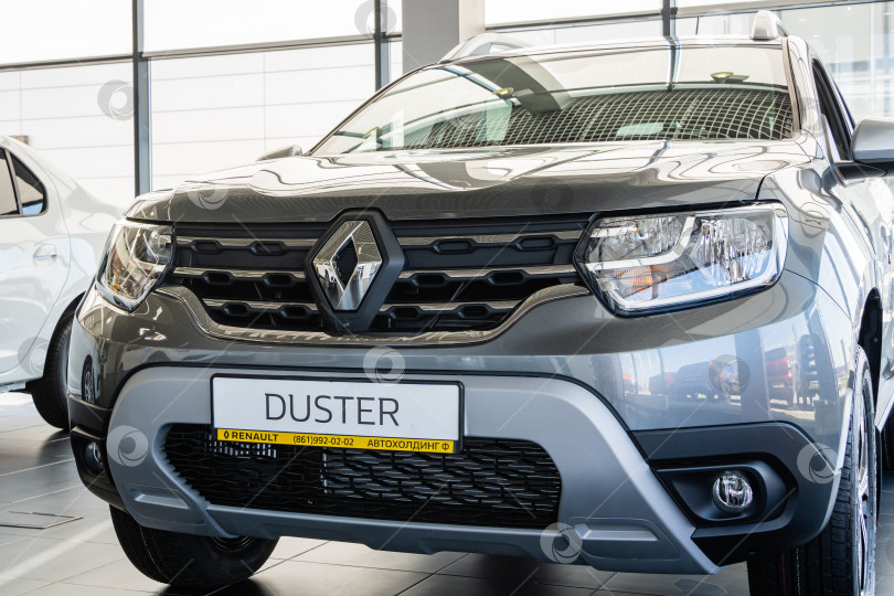 Скачать Серый внедорожник Renault Duster в автосалоне Renault. Крупный план капота с фарами и решеткой радиатора. Логотип Renault в центре. Автосалон Renault в Мега Адыгея. фотосток Ozero