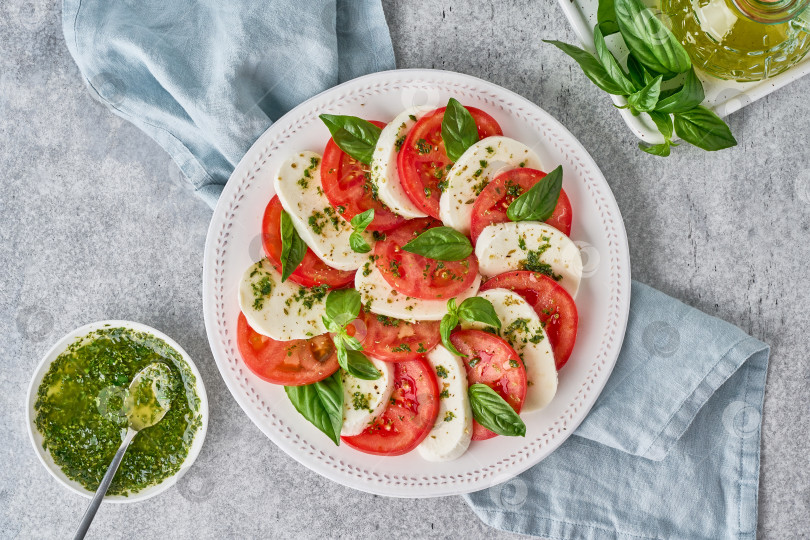 Скачать Вкусный итальянский салат капрезе с соусом песто. Национальная средиземноморская кухня. Лепешка фотосток Ozero