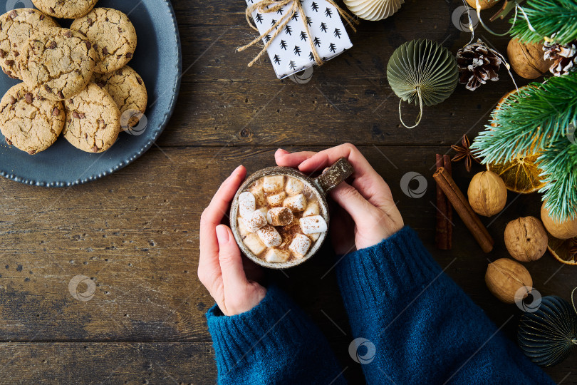 Скачать Безликая женщина держит чашку горячего шоколада с зефиром. Печенье и подарки. Рождественская концепция фотосток Ozero