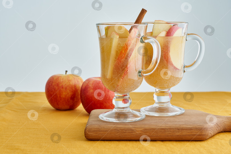 Скачать Два бокала яблочного сидра. Горячий зимний напиток с корицей, кардамоном и гвоздикой, апельсином фотосток Ozero