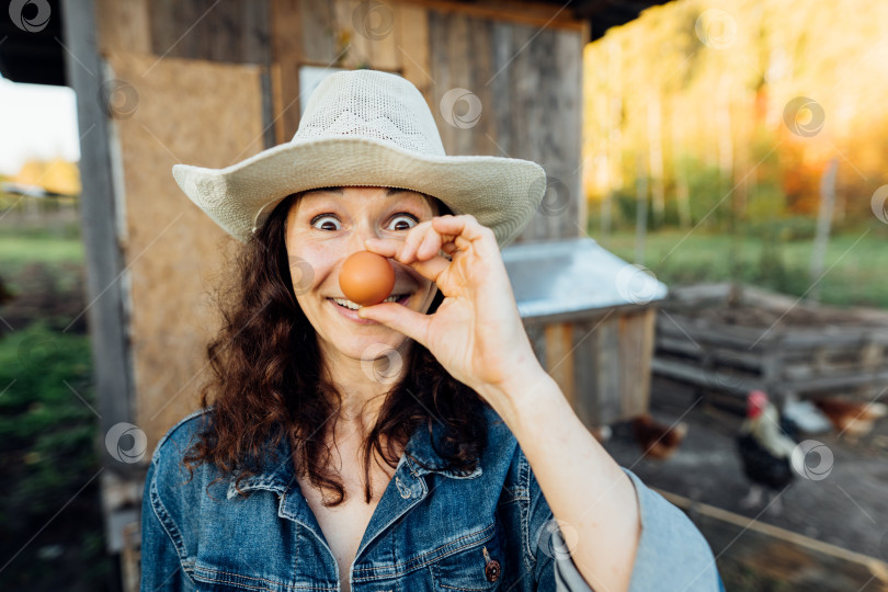 Скачать С сияющей улыбкой женщина-фермер-любитель демонстрирует идеальное яйцо фотосток Ozero