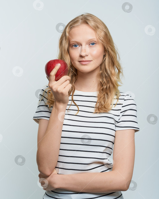 Скачать Портрет молодой улыбающейся женщины с красным яблоком. Свежее лицо, естественная красота фотосток Ozero