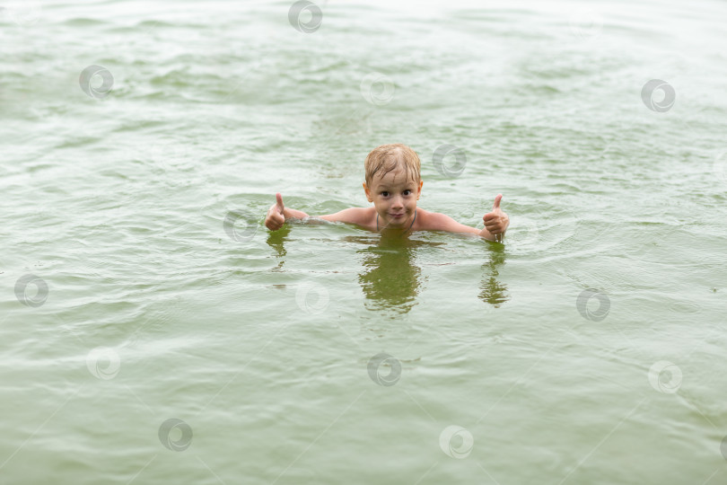 Скачать Мальчик плавает в пруду, радуется и веселится фотосток Ozero