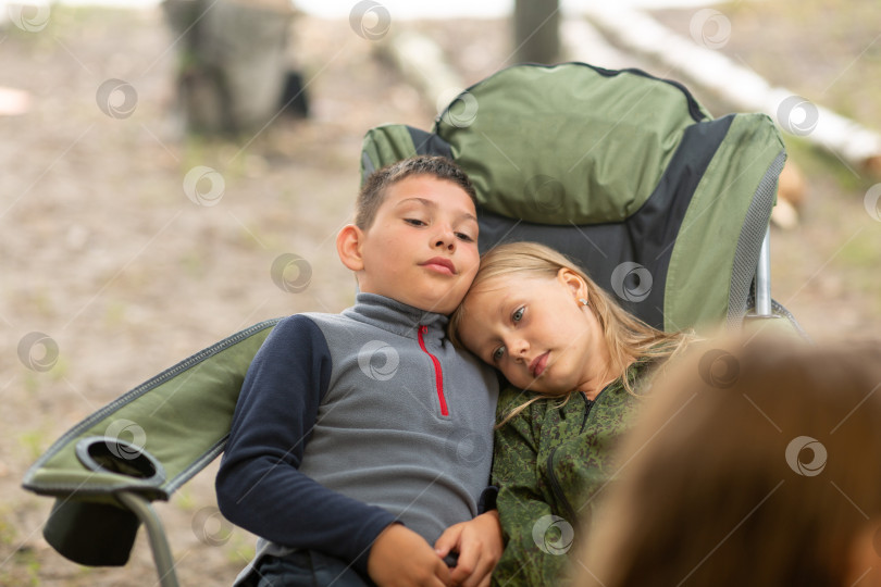 Скачать Мальчик и девочка обнимают друг друга на походном стуле фотосток Ozero