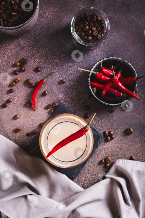 Скачать Чашка горячего пряного кофе латте с красным перцем чили на столешнице в вертикальном положении фотосток Ozero