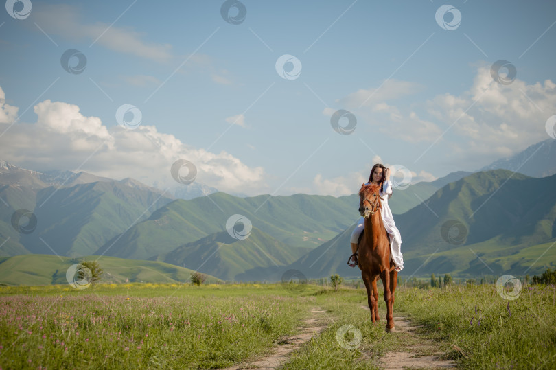 Скачать Киргизская девушка азиатской национальности скачет на лошади в белом платье фотосток Ozero