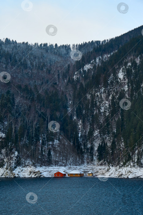 Скачать Несколько ярких домиков на берегу водоема у подножия горы. фотосток Ozero