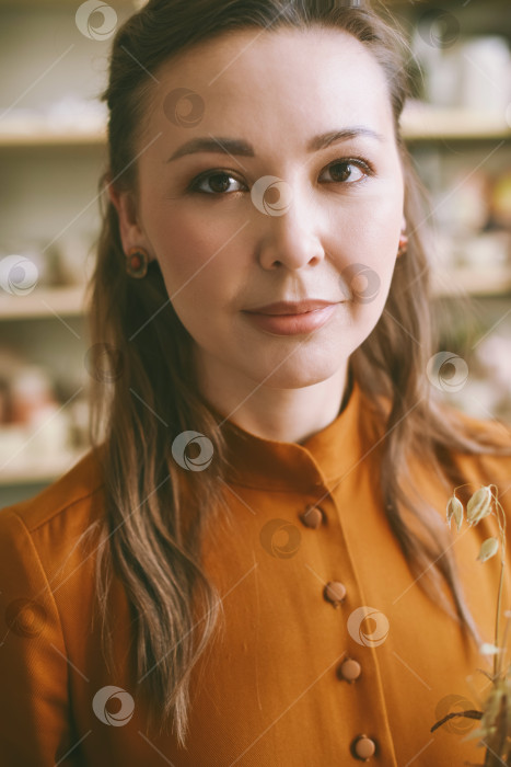 Скачать Портрет элегантной женщины крупным планом перед стеллажами с керамической посудой. фотосток Ozero