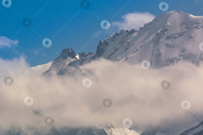 Скачать Заснеженные горные вершины среди облаков, Киргизский хребет, урочище Чонкурчак, страна Кыргызстан. Выборочный фокус фотосток Ozero