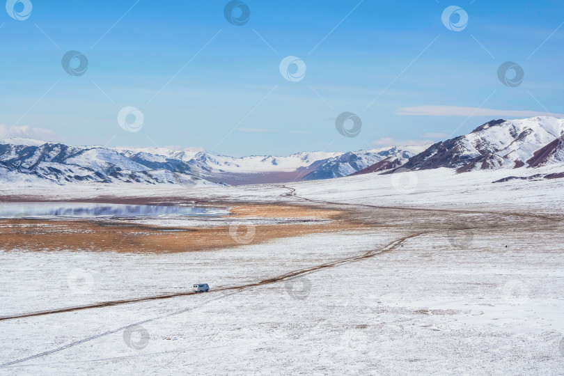 Скачать пейзаж со снежной вершиной горы и грунтовой дорогой фотосток Ozero